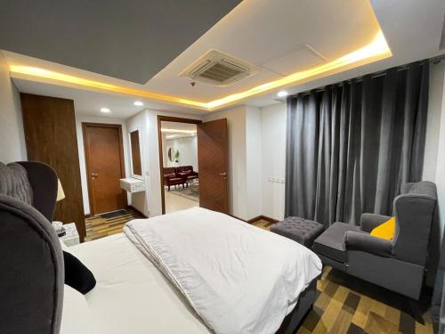 拉合尔Modern Luxury 1 BHK Apartment At Goldcrest Mall DHA Phase 4 Lahore的一间卧室，里面有一张床、一张沙发和几把椅子