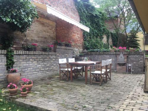 a patio with a table and chairs and a brick wall at Apartman Brankova kuća in Sremski Karlovci
