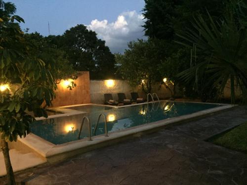 a swimming pool at night with lights around it at Hotel Rinconada del Convento in Izamal