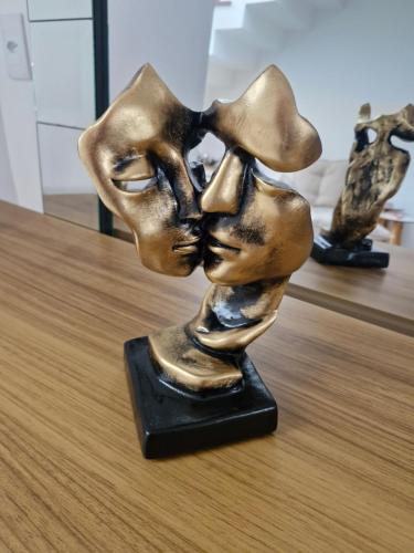 a bronze sculpture of two people kissing at Suíte tripla com vista piscina em casa familiar de luxo em Itaipu in Niterói
