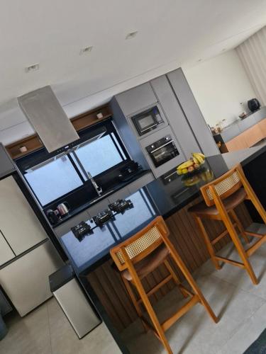 an overhead view of a kitchen with a counter and chairs at Suíte tripla com vista piscina em casa familiar de luxo em Itaipu in Niterói