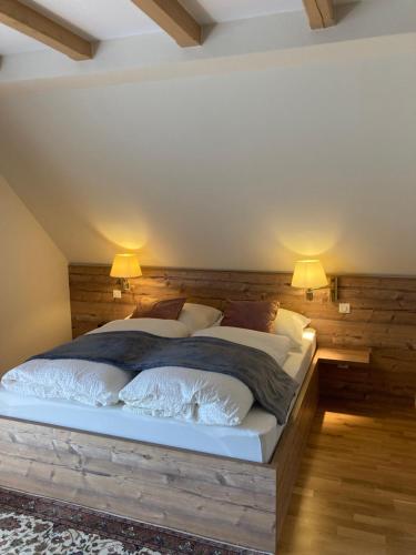 a bedroom with two beds and two lamps on the wall at Le Val Charmant in Thanvillé