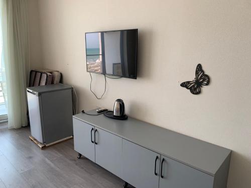 a room with a dresser with a butterfly on the wall at Astara Terrace 2-45 in Astara