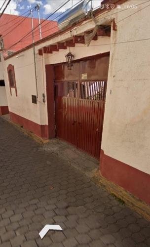 a red and white building with a gate and a brick road at Casa Villa Real in Toluca