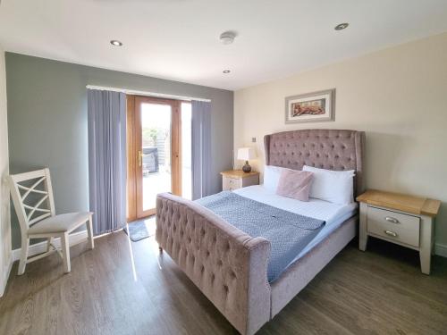 une chambre avec un grand lit et une chaise dans l'établissement Cherry 30 Hot Tub-2 Storey, à Hull