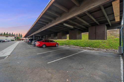 a parking lot with a red car parked under a building at Entire Private 2BR-1Bth King Bed, Pool, HotTub, 2 Parkings, Mira Mesa, Available Now in San Diego