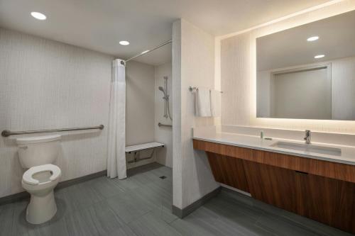 a bathroom with a toilet and a sink and a mirror at Fairfield Inn & Suites Oakland Hayward in Hayward