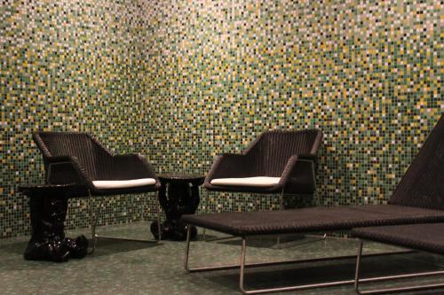 three empty chairs in a room with a wall at Crowne Plaza Antwerpen by IHG in Antwerp