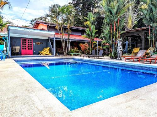 a swimming pool in front of a house at Tropical Paradise Sapacious 1 Bed Cabina AC and Pool in Herradura