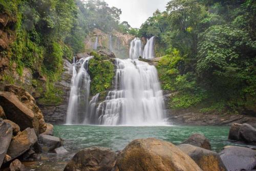a waterfall in the middle of a forest at Tropical Paradise Sapacious 1 Bed Cabina AC and Pool in Herradura