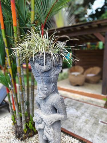 a statue of a child holding a potted plant at Tropical Paradise Sapacious 1 Bed Cabina AC and Pool in Herradura