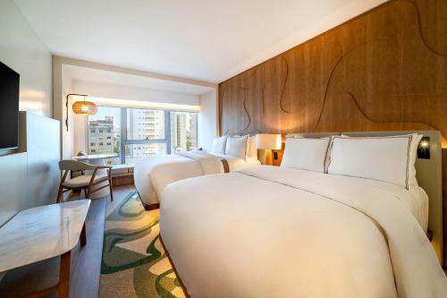 a hotel room with two beds and a window at The Westin Sao Paulo in Sao Paulo