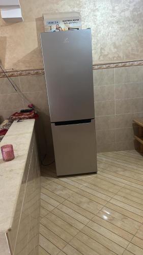 a white refrigerator sitting in a corner of a kitchen at Maison pour un séjour près de la mer in Saidia 