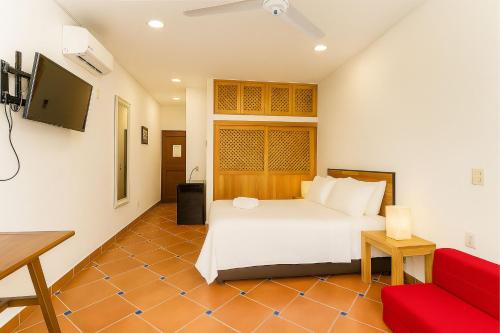 a bedroom with a white bed and a red couch at Hotelito 73 in San Francisco
