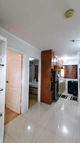 a large kitchen with white walls and a white floor at Alles One Oasis Condo Davao Near SM Mall with Wifi in Davao City