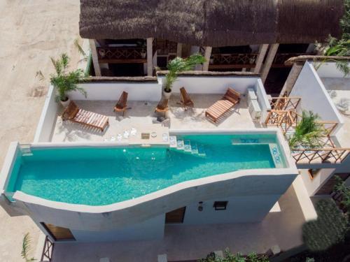 an overhead view of a swimming pool with chairs at Lagoon Boutique Hotel - Luxury Chaman experience in Tulum