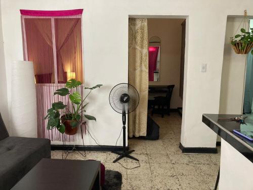 a living room with a fan next to a window at Posada Entre Dos Mundos in Cali