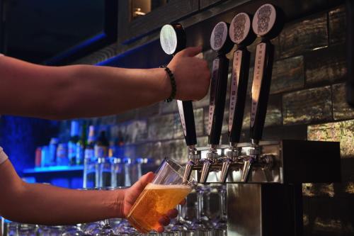 a person is holding a glass of beer at Martis Valley Lodge, Tapestry Collection by Hilton in Truckee