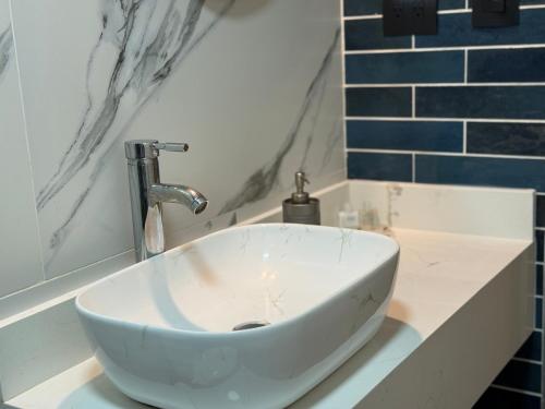 a white sink in a bathroom with blue tiles at Moderno Loft en Saltillo nuevo equipado y con Wifi rápido in Saltillo