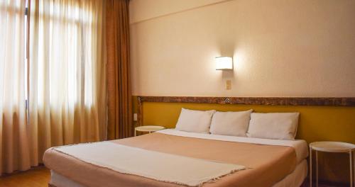 a hotel room with a bed and a window at Hotel Benedicta in Mexico City