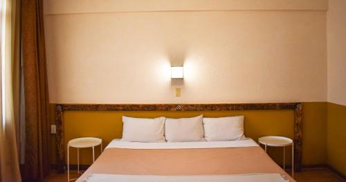 a bedroom with a bed with a light above it at Hotel Benedicta in Mexico City