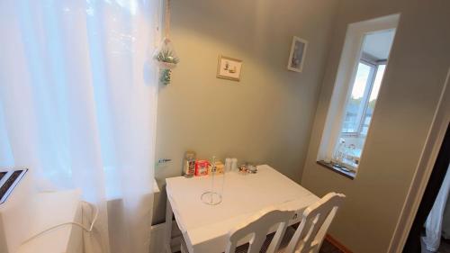 a white table and chairs in a room with a window at The castle & stay in Örebro