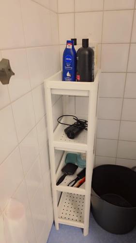 a white shelf in a bathroom with a bottle of water at The castle & stay in Örebro