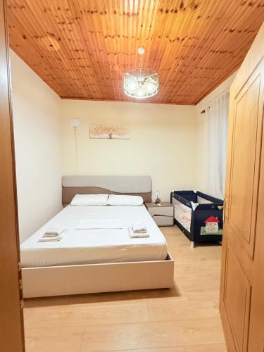 a bedroom with a bed and a wooden ceiling at La Piscina in Shkodër