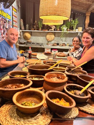 a group of people standing around a table with bowls of food at Villa Aroshina with cooking class in Galle