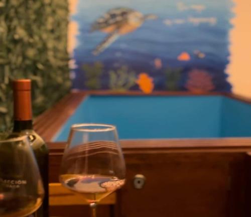 a glass of wine sitting next to a bottle of wine at Wanchaka House in Huanchaco