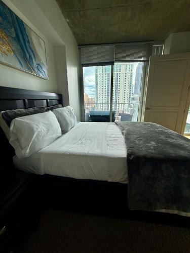 a bedroom with a large bed with a large window at Luxury Midtown High-rise Oasis! in Atlanta