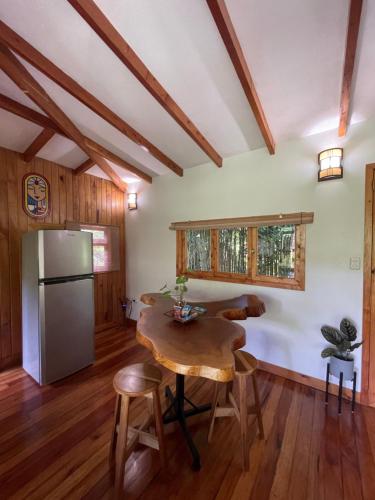 a kitchen with a wooden table and a refrigerator at Cabañita del Bambú, en Santa Maria de Dota in Higueronal