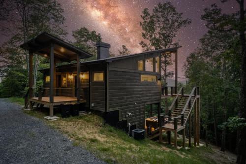 een hutje in het bos 's nachts met de Melkweg bij Mountain Abode - Luxury Cabin with Hot Tub in Blue Ridge