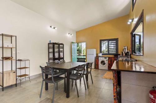 a kitchen with a table and chairs in a room at Temenino Pihiti Secluded Bungalow in Paui