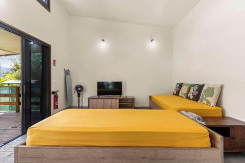 a bedroom with two beds and a television at Temenino Pihiti Secluded Bungalow in Paui