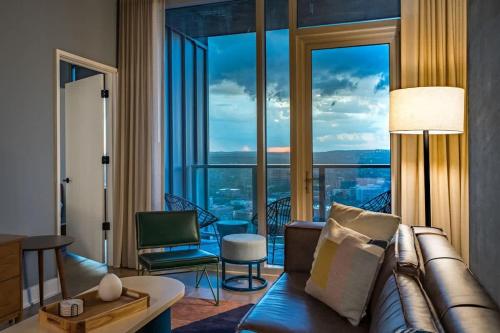 a living room with a couch and a large window at Del Rio at the Rainey District in Austin