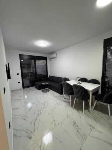 a living room with a couch and a table and chairs at Raba Apartments in Donji Štoj
