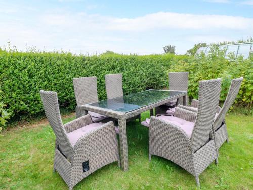 a table and four chairs with a glass table and chairs at Oxcroft View in Worksop