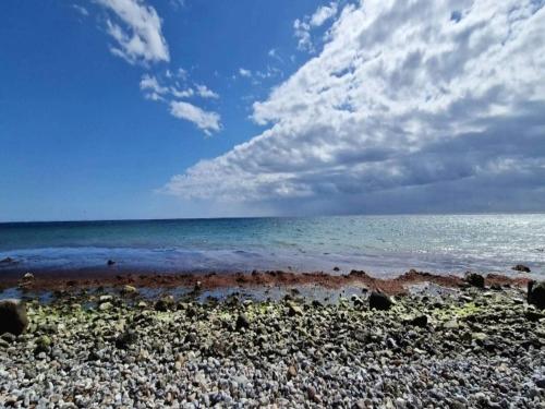 a beach with the ocean and a cloudy sky at 10 person holiday home in Marstal-By Traum in Marstal