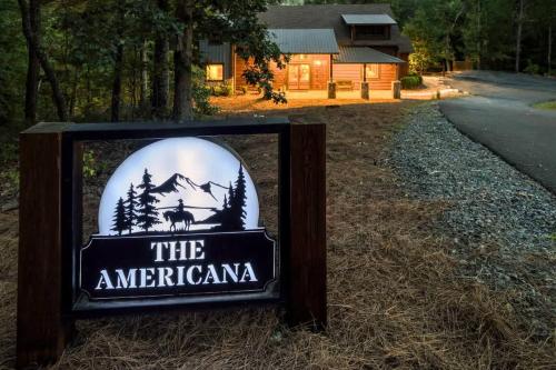 ein Schild für das Americanan Inn vor einer Hütte in der Unterkunft The Americana - Stunning Mountainside Retreat in Blue Ridge