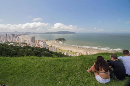 a group of people sitting on a hill overlooking a beach at Mar à porta in São Vicente