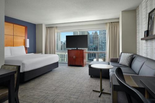 a hotel room with a bed and a couch and a tv at Residence Inn by Marriott Chicago Downtown/River North in Chicago