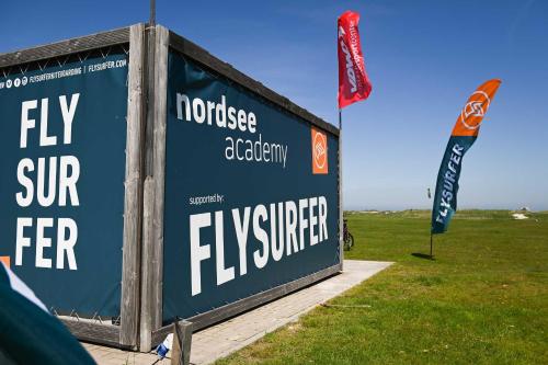 a sign that says fly surfer in a field at Tiny House Pioneer 3 - Green Tiny Spot Schillig in Wangerland