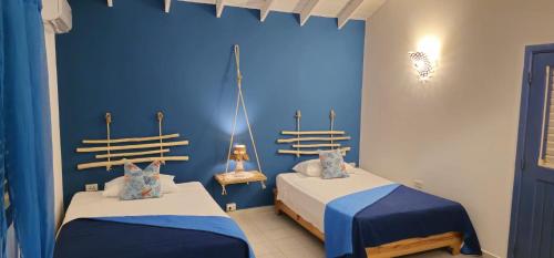 two beds in a room with blue walls at Casa Giò in Las Terrenas