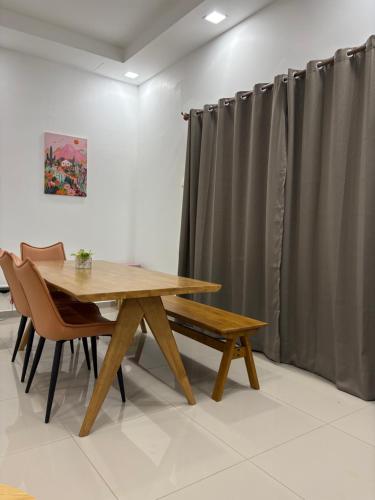 a dining room with a wooden table and chairs at See U Impiana Bentong Homestay in Bentong