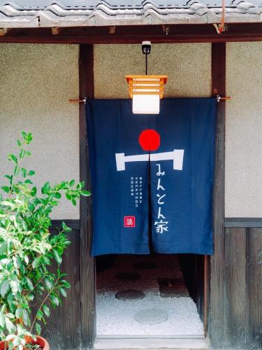 a door with a blue and white sign on it at みんとん家 in Takamatsu