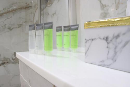 a bathroom with a white counter with green products on it at Dubai Marina 1BR with Balcony, Near Metro, Walk to JBR beach & Marina Promenade in Dubai
