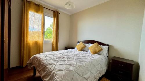 a bedroom with a bed with yellow curtains and a window at Golden View in Gaula