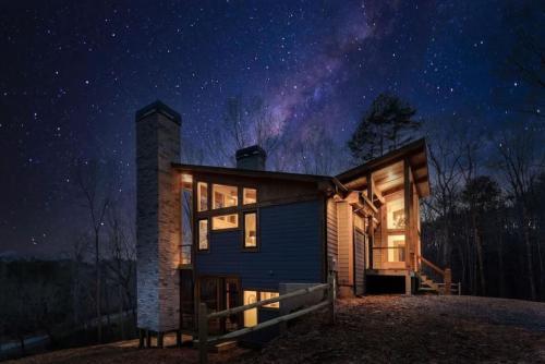 eine Hütte im Wald bei Nacht mit Sternenhimmel in der Unterkunft Modern Luxury - EV Charger Hot Tub & Epic Views in Blue Ridge
