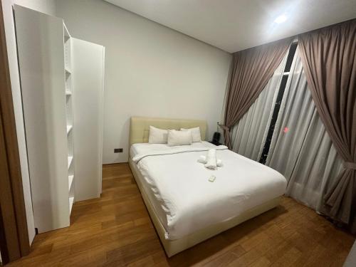 a bedroom with a white bed with a teddy bear on it at vortex suites KLCC area Dormeo in Kuala Lumpur